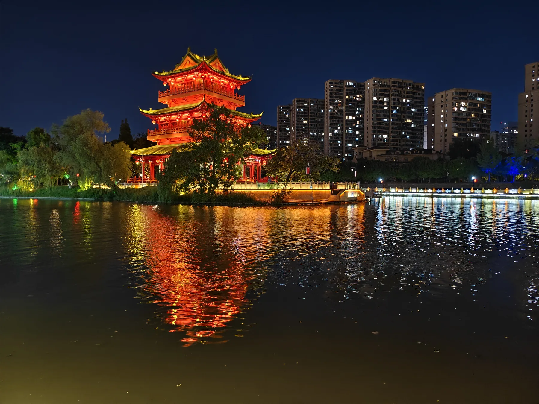 淮安中洲岛，临水楼阁倒映在里运河上，呈现清江浦夜间水岸的公共生活。